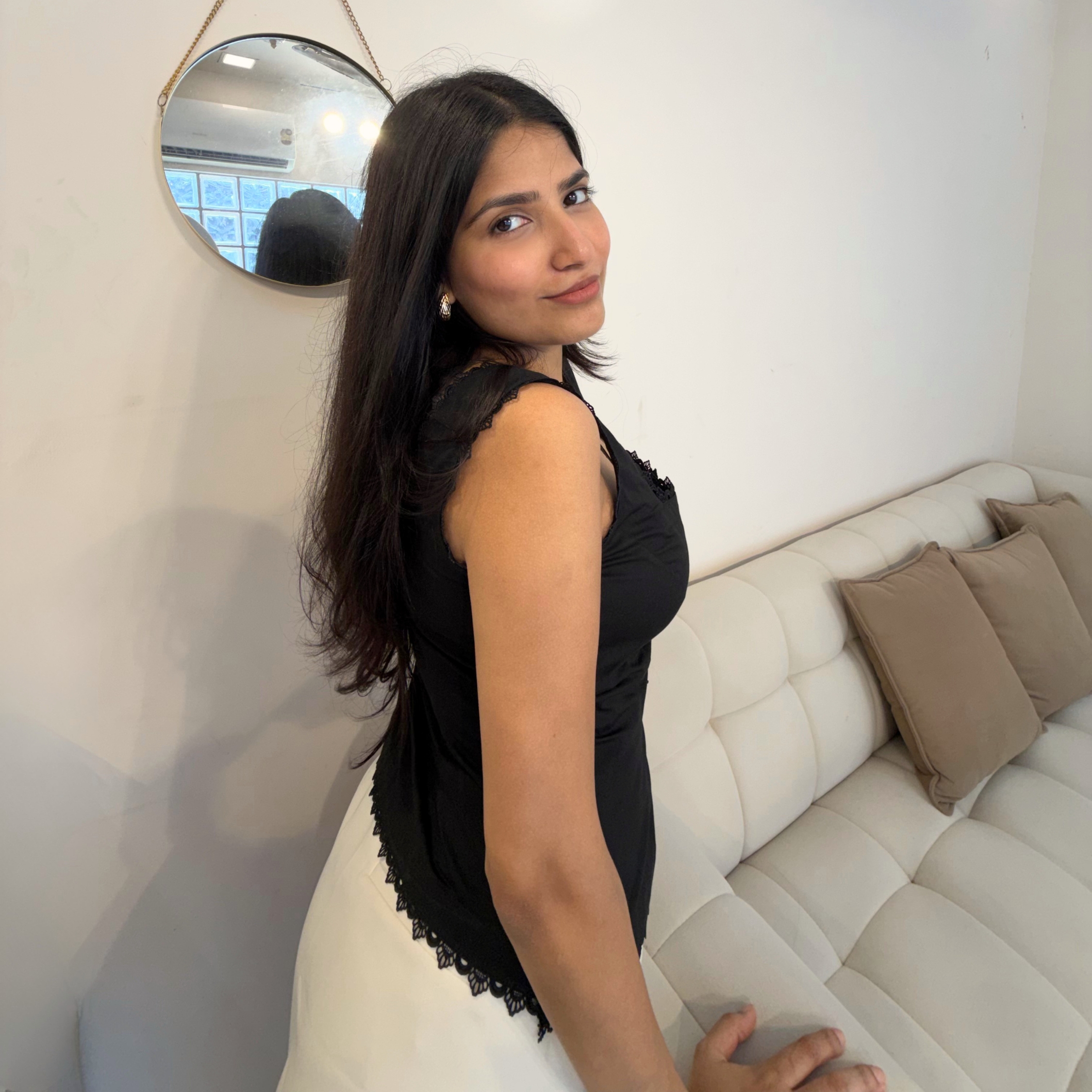 Model wearing Elara, a black cotton top with lace detailing and square neckline